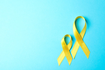 Yellow awareness ribbons on blue background, space for text.