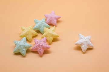 Beautiful colorful stars props placed on orange background creative top view, christmas decoration background