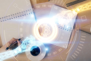 Cryptocurrency hologram over woman's hands writing background. Concept of blockchain. Double...