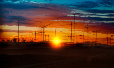 Construcción e industria inmobiliaria. Grúas y puesta de sol y cimentación de edificios ....