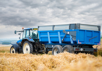 tracteur et sa remorque assortie pendant la moisson