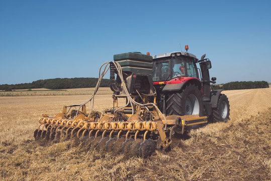 farmer plowing fields after summer grain harvest