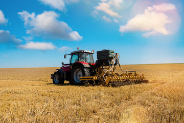Obraz premium farmer plowing fields after summer grain harvest