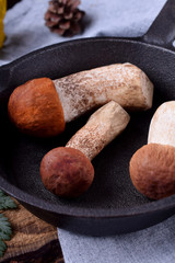 Three raw orange-cap boletus in a cast iron pan. Mushrooms for cooking a meal