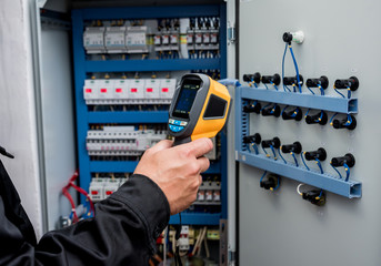Technician use infrared thermal imaging camera to check temperature at fuse-box