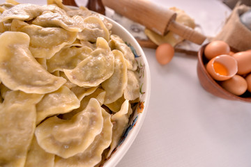 ready-made dumplings Ukrainian national dish in a painted dish on a board with ingredients of eggs and flour