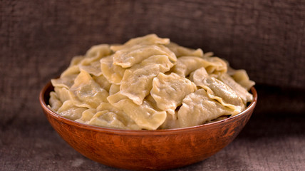 dumplings in a large clay dish on a dark background