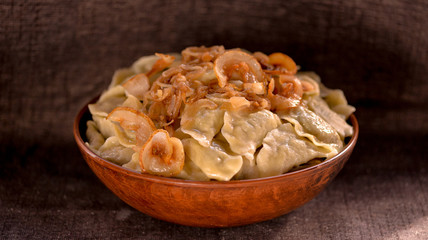 dumplings in a large clay dish on a dark background
