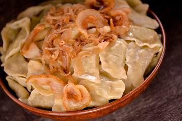 dumplings in a large clay dish on a dark background