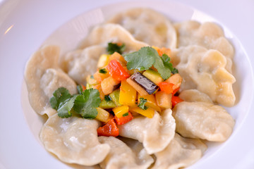 Dumplings are ready in a white plate with vegetables