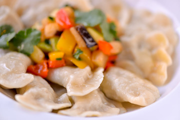 Dumplings are ready in a white plate with vegetables