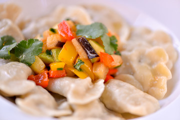 Dumplings are ready in a white plate with vegetables