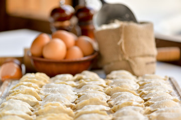 semi-finished dumplings Ukrainian national dish on a board with ingredients eggs and flour