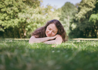 Young, cute woman relaxing in  summer park. Outdoor lifestyle.