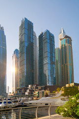 Obraz premium Dubai, UAE United Arabs Emirates. Dubai marina skyscrapers and yachts at sunset. Apartments, hotels and office buildings, modern residential development of UAE