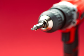 Battery screwdriver or drill on red background presentation
