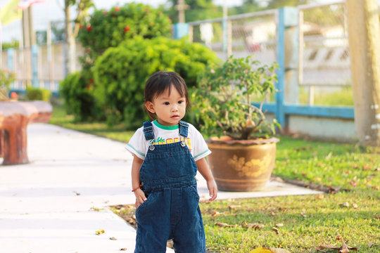 Portrait image of 1 years and 4 months olds baby girl walking in to the nature park. Relaxing of happy Asian kid in the summer season.