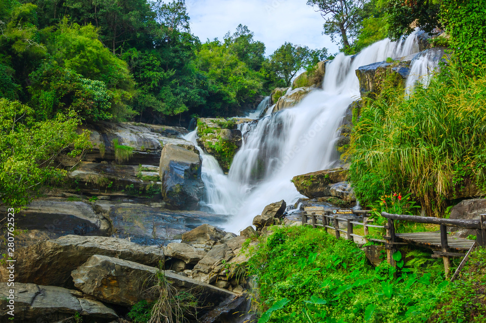 Wall mural beautiful waterfall in green forest shoot by slow shutter speed to make the water look softer,mae kl