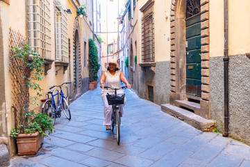 Woman Riding A Bike In Italy - obrazy, fototapety, plakaty