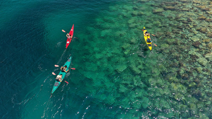 Aerial drone photo of colourful sport canoes operated by young athletes competing in Mediterranean bay with crystal clear turquoise sea