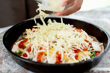 Put the cheese on the pizza in the tray.