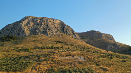Aerial drone panoramic view of iconic uphill medieval castle of Acrocorinth an ancient citadel overlooking ancient Corinth, Peloponnese, Greece