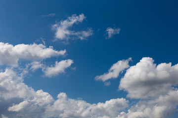 Naklejka na ściany i meble Cumulus fluffy clouds in the blue sky. Harbingers of rain. Sky pattern. 