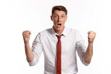 Portrait of a young brunet man posing in a studio isolated over a white background.