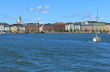 Obraz premium Pohjoisranta embankment, harbor with yacht on background of Finnish Evangelical Lutheran cathedral of Diocese. Helsinki, Finland