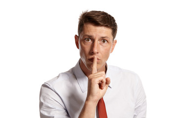 Portrait of a young brunet man posing in a studio isolated over a white background.
