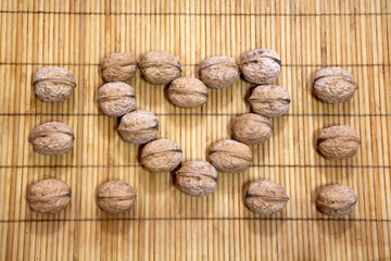 walnut heart symbol wooden background 