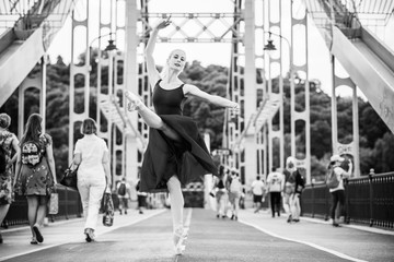 Young ballerina dancing in city streets, feeling breath of big city life and freedom 