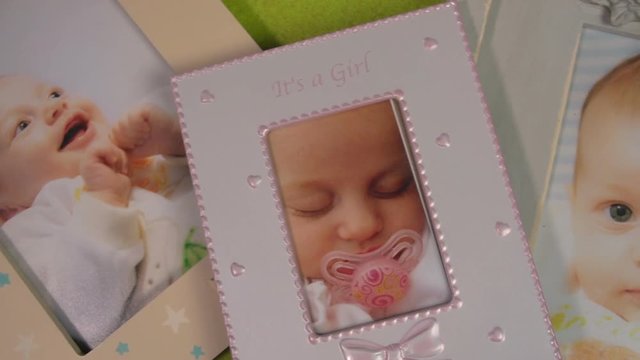 Cute baby photos  in its frames are showed in slow panning on green background FDV