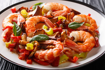 Grilled shrimps with mushrooms and summer vegetables close-up on a plate. horizontal