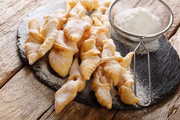 Freshly made Angel Wings Cookies with powdered sugar close-up on the table. horizontal