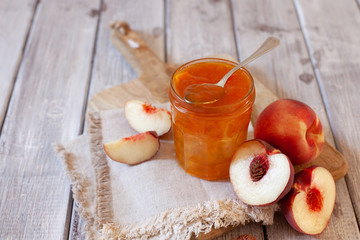 Sweet homemade peach jam on the wooden table