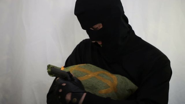 Young cheeky Caucasian robber with a gun lulls a bag of money and rejoices in prey, close-up