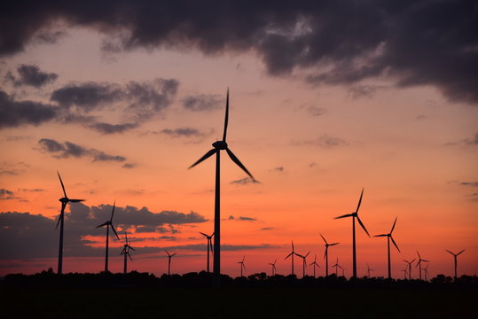 Wind turbines for green energy generation at dusk in Burgenland.