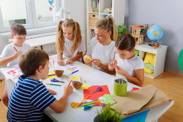 Mother or school teacher with children. Creative arts and crafts project at school or at home.