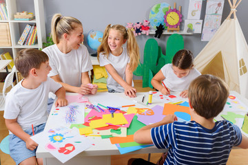 Mother or school teacher with children. Creative arts and crafts project at school or at home.