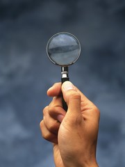hand holding magnifying glass