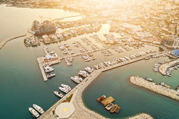 Aerial drone shot of Limassol Marina, Cyprus, at sunset. Yachts and boats docket. Modern luxury villas and construction of a new estate. © footagelab
