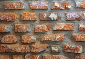 Photo background wall of brown old decorative brick with scratches, scuffs, cracks.