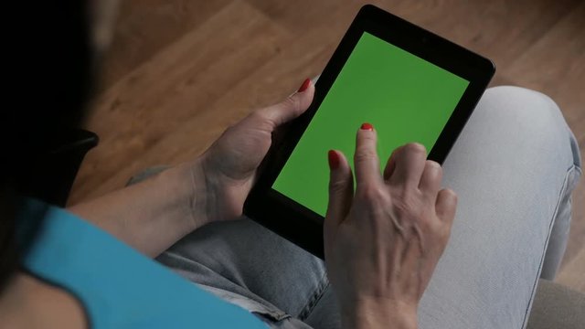  Woman Holding A Tablet In The Hands Of A Green Screen Green Screen, Hand Of Man Holding Mobile Smart Phone With Chroma Key Green Screen On White Background.Girl Using Digital Tablet.  Technology.