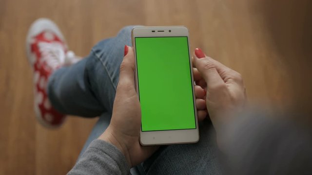 Technology concept. Girl using cell phone.  Woman holding a smartphone in hands of a green screen green screen, hand of man holding mobile smart phone with chroma key green screen on white background.