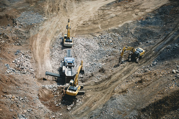 Excavator loading dumper truck on mining site stock photo