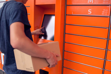 Client using automated self service post terminal machine or locker to deposit a parcel for storage