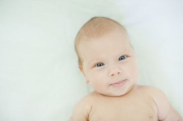 Close-up of three months old baby girl with blue eyes. Newborn child, little adorable smiling girl...