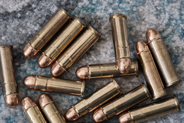 Brass handgun ammunition against a wooden backdrop