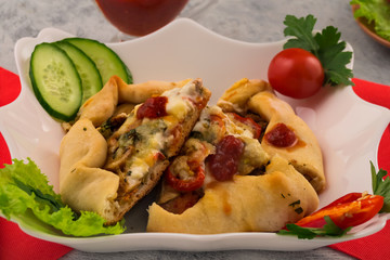 Mini pizza with cheese, mushrooms and tomatoes in a white plate. Slices of fresh vegetables. Spicy tomato sauce. Tasty and fast food.